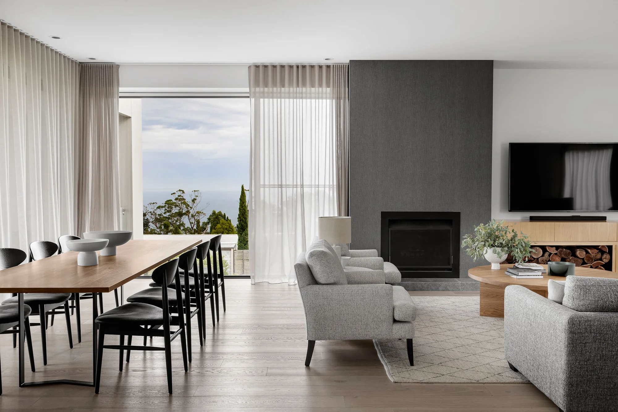 Expansive open-plan living and dining interior with full-height glazing and an ocean outlook