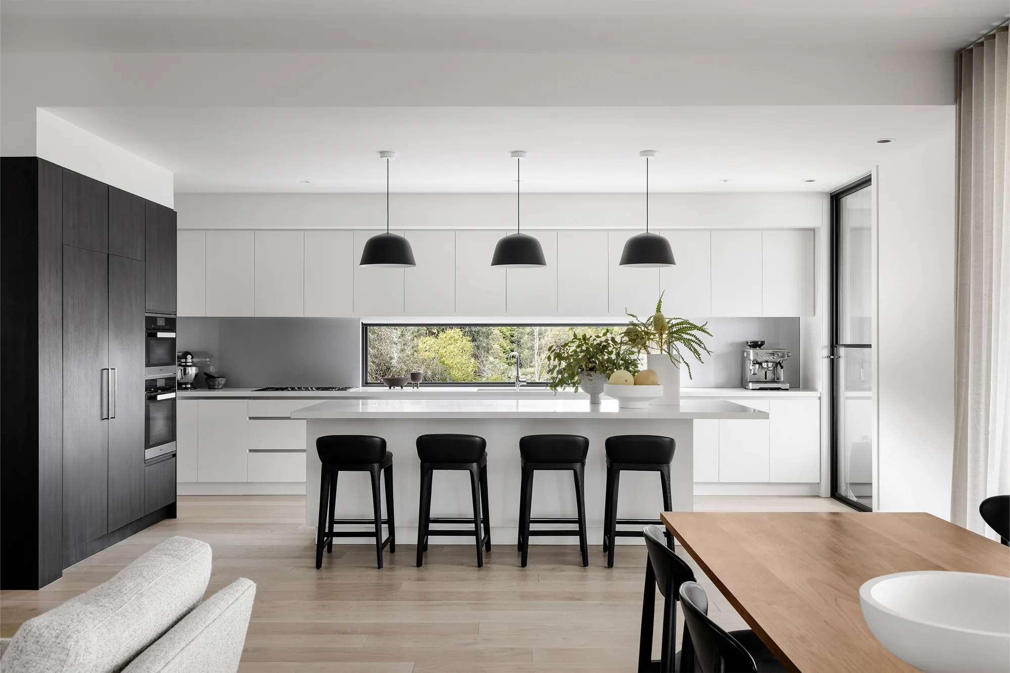 Contemporary kitchen with a large island, dark timber cabinetry and pendant lighting